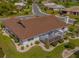 Aerial view of the home featuring a backyard screen enclosed lanai and manicured landscape at 702 Plumbrook Rd, Sun City Center, FL 33573