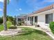 Landscaped backyard featuring a screened-in lanai and decorative stone accents at 702 Plumbrook Rd, Sun City Center, FL 33573