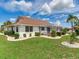 View of the home's landscaped backyard, screen enclosed lanai, and verdant lawn at 702 Plumbrook Rd, Sun City Center, FL 33573