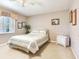 A bedroom with an floral-patterned comforter on the bed and a window letting in natural light at 702 Plumbrook Rd, Sun City Center, FL 33573