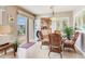 Bright dining area with wicker seating, adjacent to kitchen and sliding glass door to patio at 702 Plumbrook Rd, Sun City Center, FL 33573