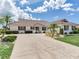 Charming home with a tile roof, palm trees, and large driveway at 702 Plumbrook Rd, Sun City Center, FL 33573