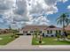 Well-manicured front yard highlighting lush landscaping, mature palms, and inviting curb appeal at 702 Plumbrook Rd, Sun City Center, FL 33573
