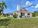 Rear exterior showcasing a well maintained backyard and beautiful red tiled roof at 702 Plumbrook Rd, Sun City Center, FL 33573