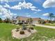 Inviting front exterior featuring manicured landscaping, mature trees, and a well-maintained lawn at 702 Plumbrook Rd, Sun City Center, FL 33573