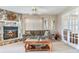 Cozy living room with stone fireplace, neutral decor, and plenty of seating at 702 Plumbrook Rd, Sun City Center, FL 33573