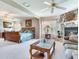 Bright main bedroom with a stone fireplace, ceiling fan, and neutral carpeting at 702 Plumbrook Rd, Sun City Center, FL 33573