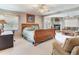Spacious main bedroom features a stone fireplace, ceiling fan, and neutral carpeting at 702 Plumbrook Rd, Sun City Center, FL 33573