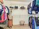 A walk-in closet featuring organized shelving and a basket in the center with a stool at 702 Plumbrook Rd, Sun City Center, FL 33573