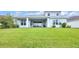 Spacious backyard with a covered patio, expansive lawn, and meticulously maintained landscaping at 7201 Talamore Dr, Wesley Chapel, FL 33545