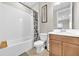 A bathroom with white tile walls and patterned shower curtain for style at 7201 Talamore Dr, Wesley Chapel, FL 33545