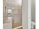 Bright bathroom featuring glass enclosed shower, neutral tile, and modern fixtures at 7201 Talamore Dr, Wesley Chapel, FL 33545