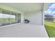 Covered patio with sliding glass doors, featuring an outdoor kitchen and stunning landscape views at 7201 Talamore Dr, Wesley Chapel, FL 33545