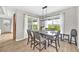 Bright dining area featuring a dark wood table, six chairs, and views of the backyard at 7201 Talamore Dr, Wesley Chapel, FL 33545