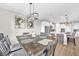 Dining room with wood table, stylish light fixture, and open layout into the kitchen at 7201 Talamore Dr, Wesley Chapel, FL 33545