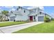 Inviting two-story home featuring a well-manicured lawn, two-car garage, and an inviting red front door at 7201 Talamore Dr, Wesley Chapel, FL 33545