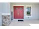 Charming red double front door surrounded by decorative stone accents and a welcoming sign at 7201 Talamore Dr, Wesley Chapel, FL 33545