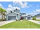 Attractive two-story home with a manicured lawn, three-car garage, and charming red front door creates curb appeal at 7201 Talamore Dr, Wesley Chapel, FL 33545