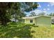 Backyard featuring lush lawn, mature trees, and a storage shed at 7308 Avonwood St, Tampa, FL 33625