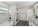 Stylish bathroom featuring a soaking tub, step-in shower, granite countertops, and modern black fixtures at 7308 Avonwood St, Tampa, FL 33625