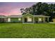 Charming, updated single-story home features a cozy front porch and lush green lawn at 7308 Avonwood St, Tampa, FL 33625