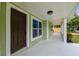 Covered front porch with a dark wood door and ample space for relaxing outdoors at 7308 Avonwood St, Tampa, FL 33625