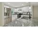Modern kitchen featuring stainless steel appliances, granite countertops, and sleek white cabinetry at 7308 Avonwood St, Tampa, FL 33625