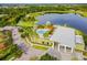 A high angle aerial view of the community clubhouse with a resort-style pool, lake, and surrounding green spaces at 7520 Paradiso Dr, Apollo Beach, FL 33572