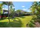 Lush backyard with manicured lawn, tropical landscaping, and a screened-in lanai, creating a private outdoor oasis at 7520 Paradiso Dr, Apollo Beach, FL 33572