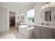 Elegant bathroom featuring a freestanding tub with dual vanities and a glimpse of a walk-in closet at 7520 Paradiso Dr, Apollo Beach, FL 33572