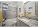 Stylish bathroom with granite countertop, decorative mirror, and tub with shower at 7520 Paradiso Dr, Apollo Beach, FL 33572