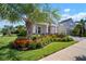 Charming single-Gathering home featuring lush landscaping, a well-manicured lawn, and a welcoming entrance at 7520 Paradiso Dr, Apollo Beach, FL 33572
