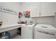 Well-organized laundry room with a countertop, storage cabinets, and a washer and dryer at 7520 Paradiso Dr, Apollo Beach, FL 33572