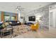 Spacious living room with stylish decor, including a stone accent wall and modern furnishings at 7520 Paradiso Dr, Apollo Beach, FL 33572