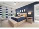 Luxurious main bedroom with a blue accent wall, tray ceiling, and elegant ensuite bathroom at 7520 Paradiso Dr, Apollo Beach, FL 33572