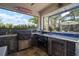Fully equipped outdoor kitchen under a screened enclosure with a built-in grill, refrigerator, and sink at 7520 Paradiso Dr, Apollo Beach, FL 33572