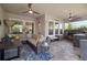 Inviting outdoor living space with comfortable seating, ceiling fans, and a fully-equipped outdoor kitchen area at 7520 Paradiso Dr, Apollo Beach, FL 33572