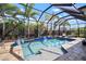 Inviting screened-in pool area featuring a sparkling pool, waterfall feature, and comfortable lounging space at 7520 Paradiso Dr, Apollo Beach, FL 33572