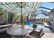 Relaxing screened-in pool area with a dining table and comfortable seating, perfect for outdoor entertaining at 7520 Paradiso Dr, Apollo Beach, FL 33572