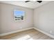 A vacant bedroom featuring a window, neutral paint, and light wood-look flooring at 7806 N Matanzas Ave, Tampa, FL 33614