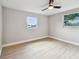 An empty bedroom featuring two windows, a ceiling fan, neutral walls, and wood-look flooring at 7806 N Matanzas Ave, Tampa, FL 33614