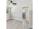 Well-lit bedroom featuring a ceiling fan, hardwood floors, and an adjacent bathroom at 7806 N Matanzas Ave, Tampa, FL 33614