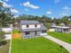 Lovely home featuring a lush green front yard, with a paved driveway and a well-kept exterior at 7806 N Matanzas Ave, Tampa, FL 33614