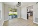 Open living room featuring an adjoining kitchen, laminate floors, and a sliding glass door to the backyard at 7806 N Matanzas Ave, Tampa, FL 33614