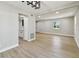 Bright living room featuring adjoining kitchen, modern light fixture, and neutral walls at 7806 N Matanzas Ave, Tampa, FL 33614