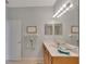 Well-lit bathroom with a double vanity, framed art, and a decorative towel arrangement at 8251 118Th Ave # 8251, Largo, FL 33773