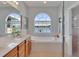 A bright bathroom with a soaking tub with a large window overlooking a scenic view at 8251 118Th Ave # 8251, Largo, FL 33773