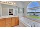 Bright bathroom features a soaking tub with a large window overlooking a scenic view at 8251 118Th Ave # 8251, Largo, FL 33773