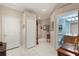 Neutral hallway with decor, white tiled floor, and access to a bathroom at 8251 118Th Ave # 8251, Largo, FL 33773
