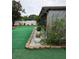Landscaped backyard with artificial turf and decorative stone edging at 8718 Lindenhurst Pl, Tampa, FL 33634